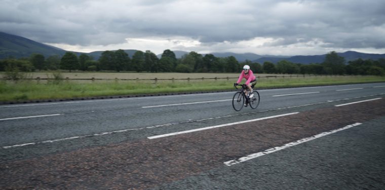 Cyclist on the bike course with Lake District fells behind